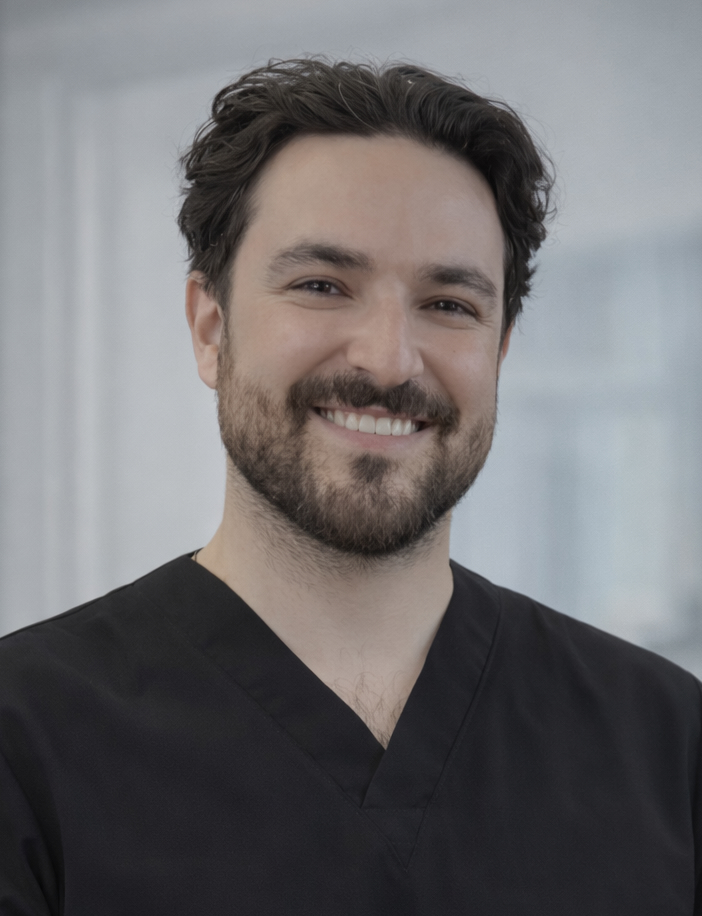 Connor Medgaus, DMD, in black scrubs, smiling